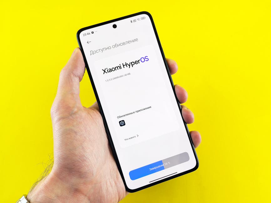 Hand holding smartphone showing Xiaomi HyperOS update screen on yellow background.